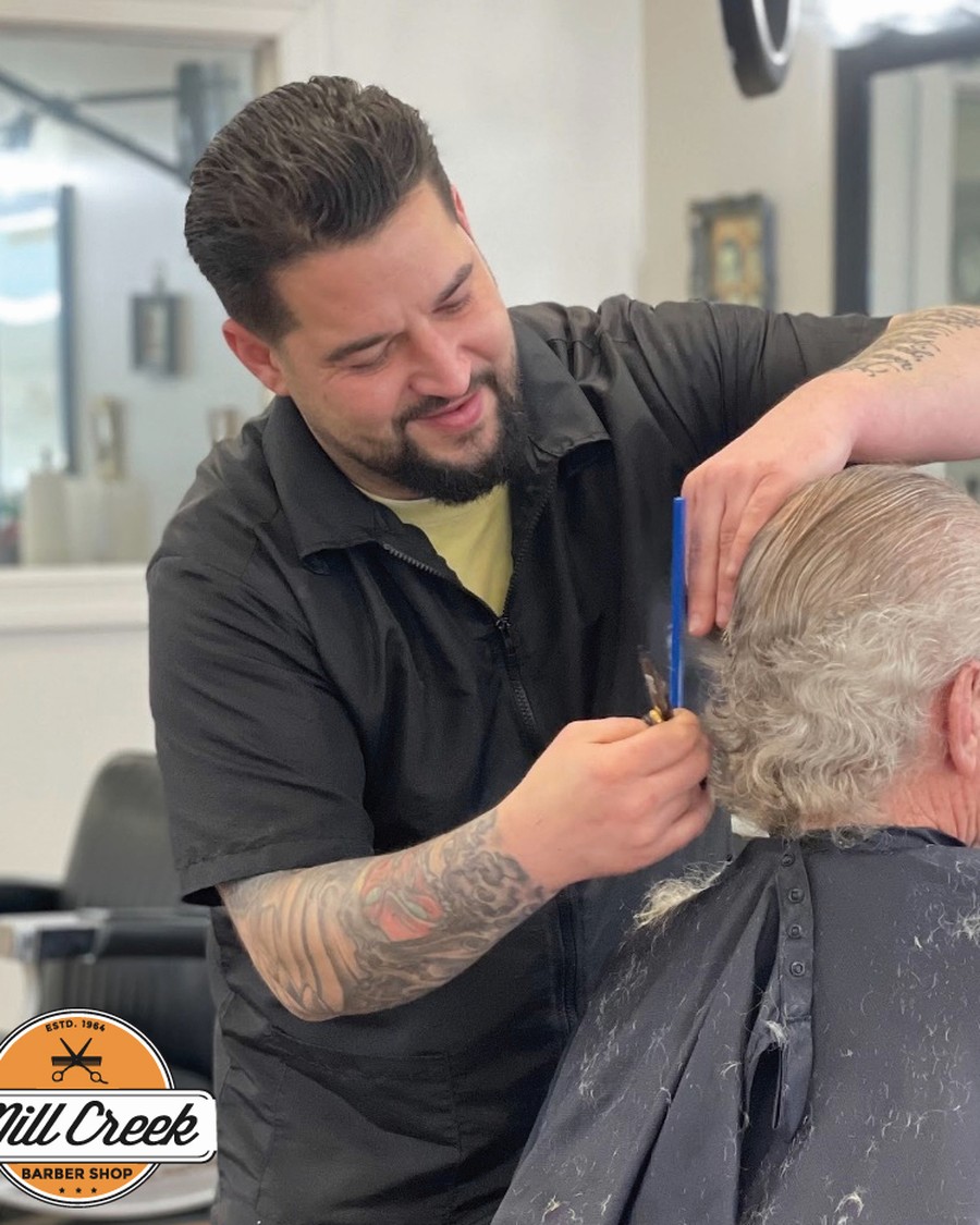 Barber working with a client at Mill Creek Barbershop